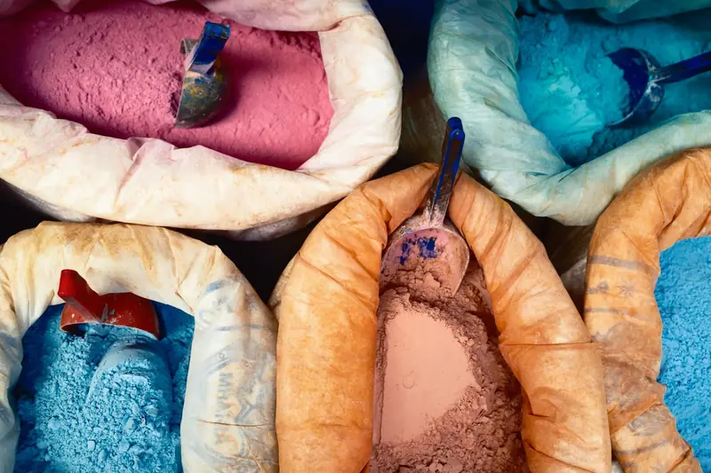 Vibrant colored dye powders in sacks at a market, showcasing traditional craftsmanship