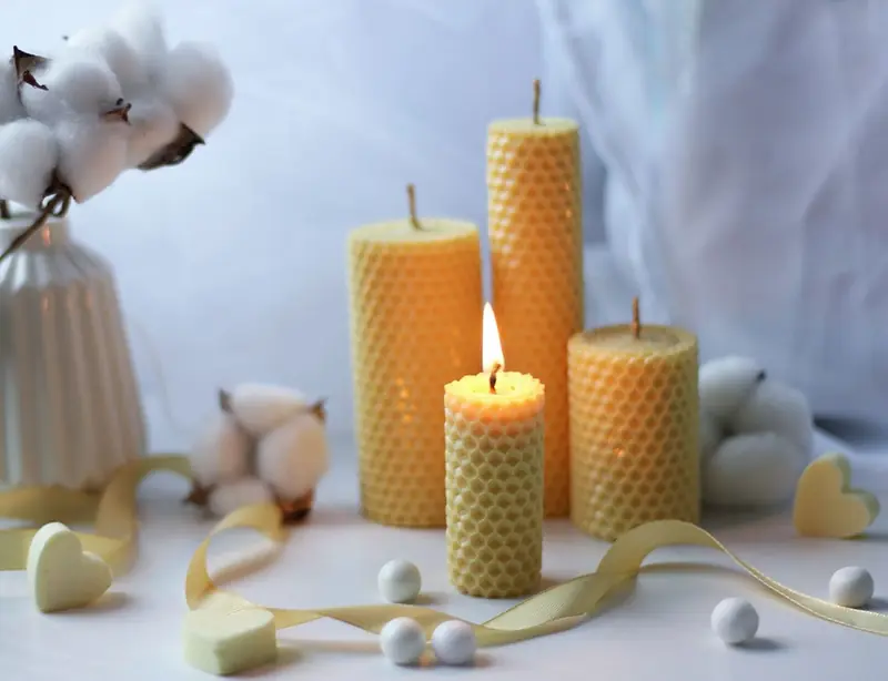 Warm and cozy candlelight scene with aromatic beeswax candles and soft cotton decor, creating a tranquil atmosphere